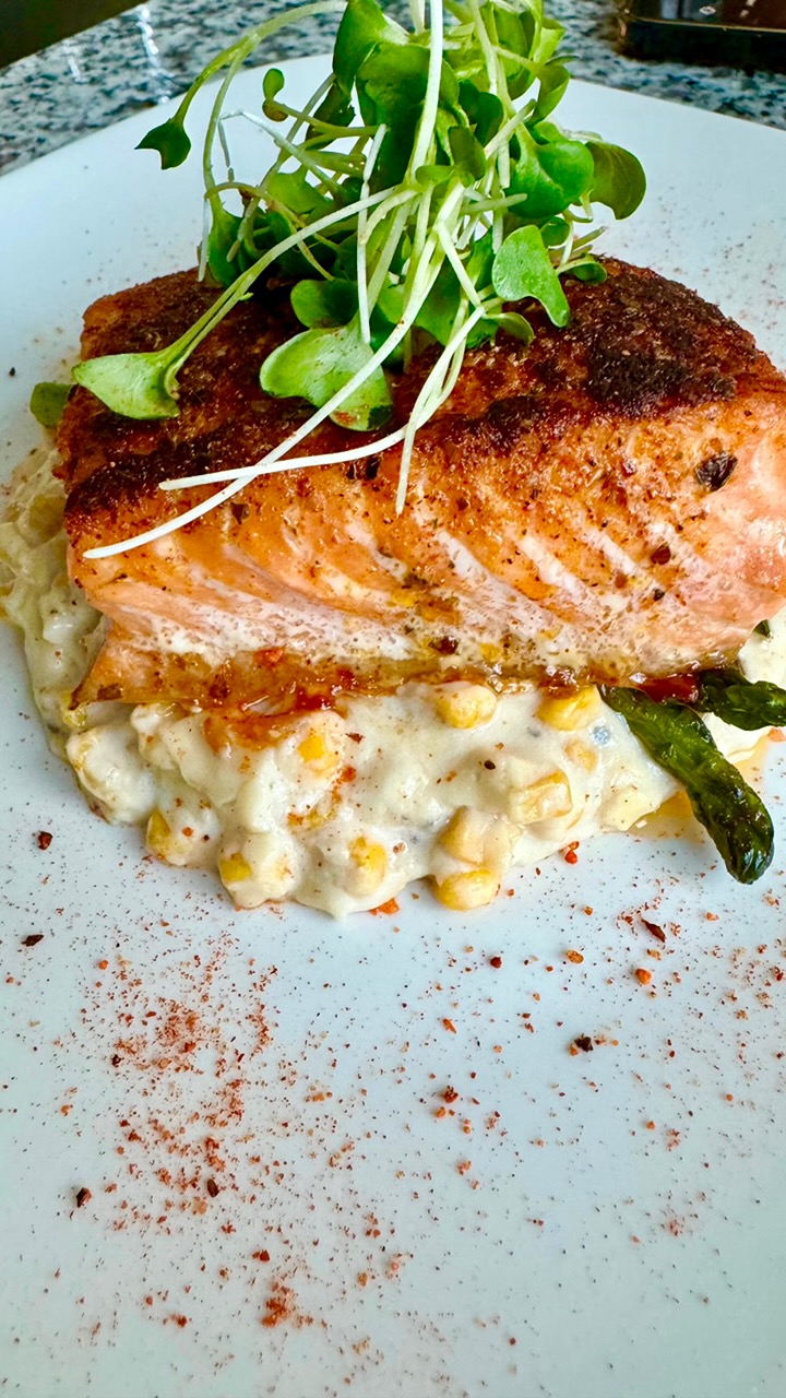 Blackened salmon on creamed corn with asparagus and micro greens