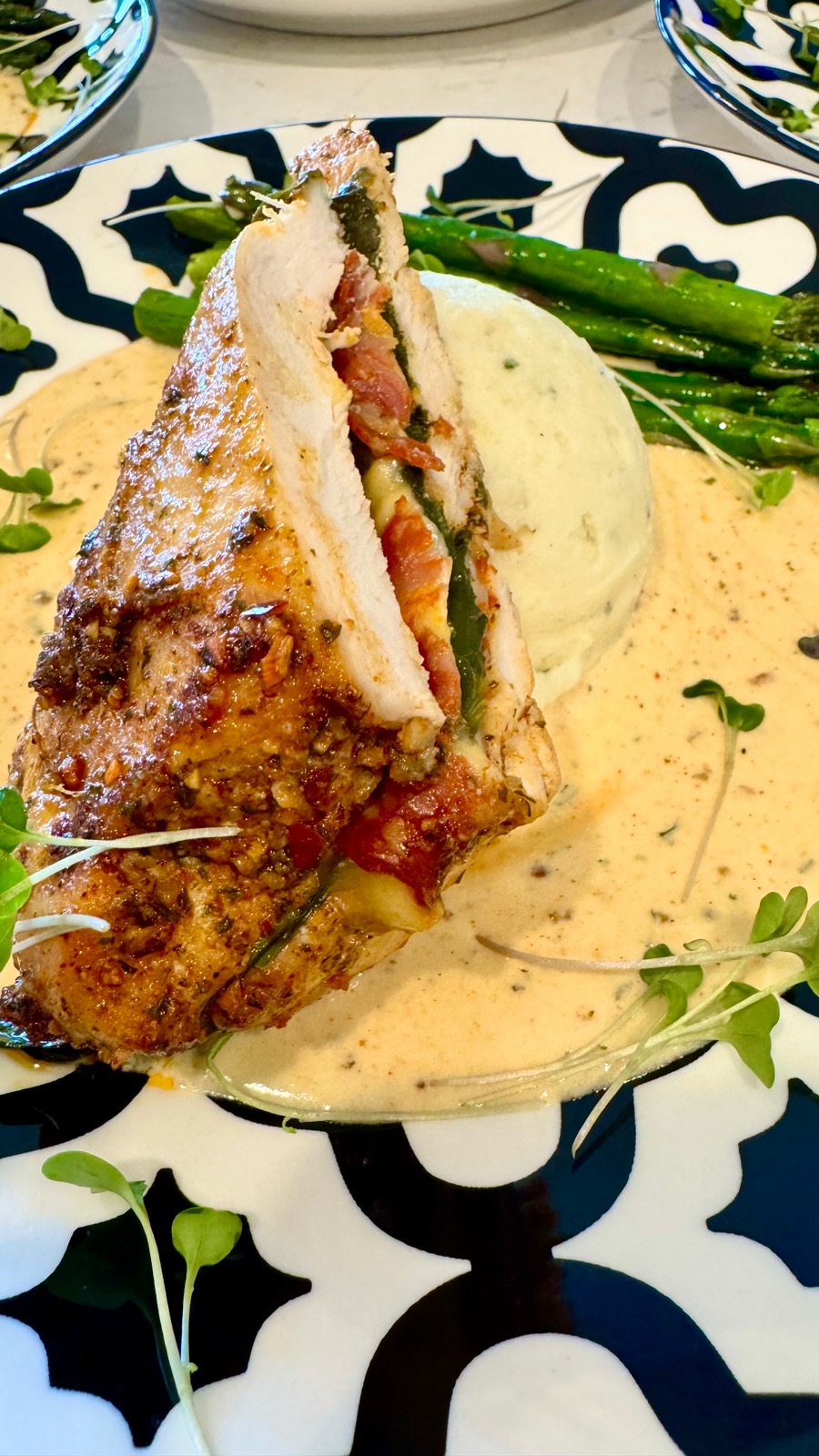 Stuffed chicken breast with prosciutto and basil over herb purée