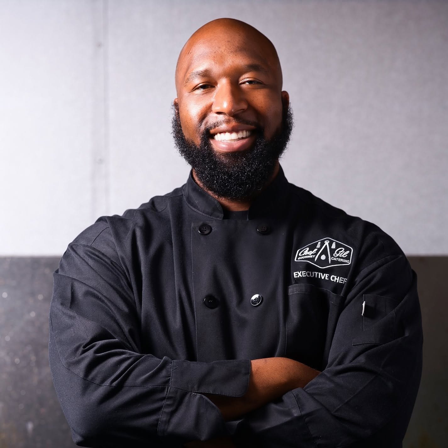 Chef Gilfert Hunt in a black executive chef coat, arms crossed